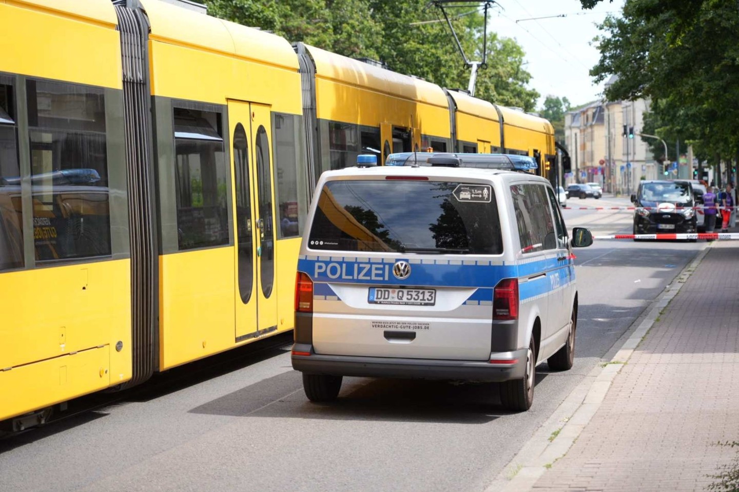 Ein Polizeiauto steht vor der Straßenbahn in Desden, in der ein Mann mit einem Messer attaktiert wurde.