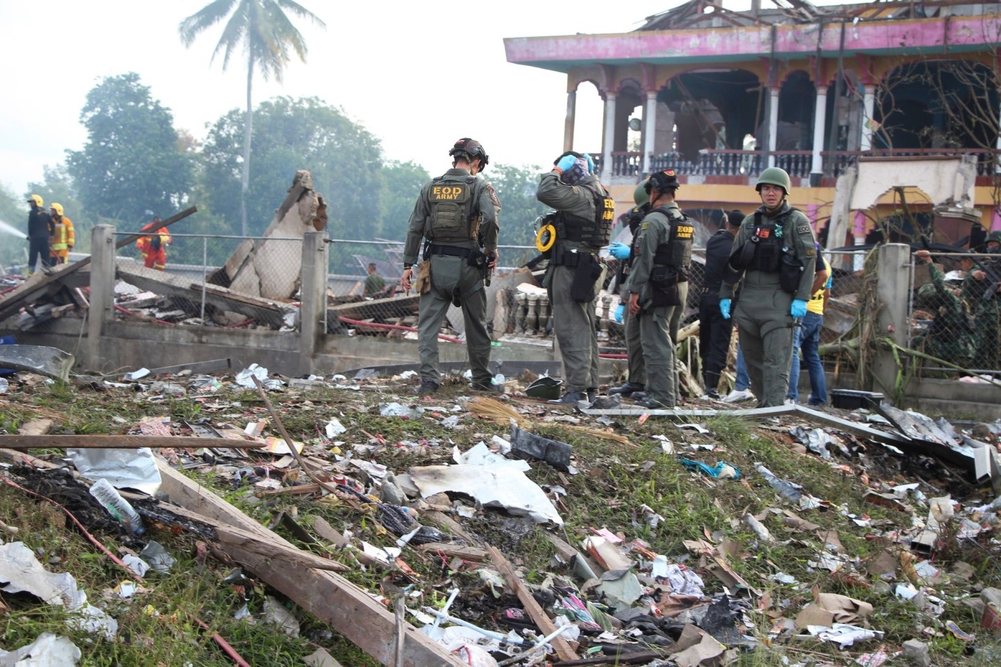 Einsatzkräfte des Kampfmittelräumdienstes untersuchen die Überreste eines durch eine Explosion zerstörten Gebäudes im thailändischen Narathiwat.
