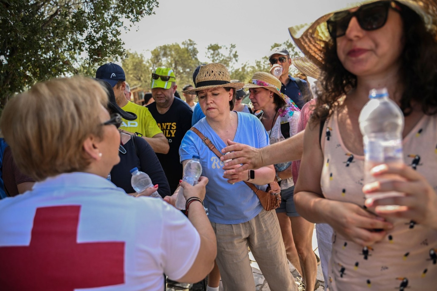 Mitarbeiter des Griechischen Roten Kreuzes verteilen vor der Akropolis Wasserflaschen an Besucher.