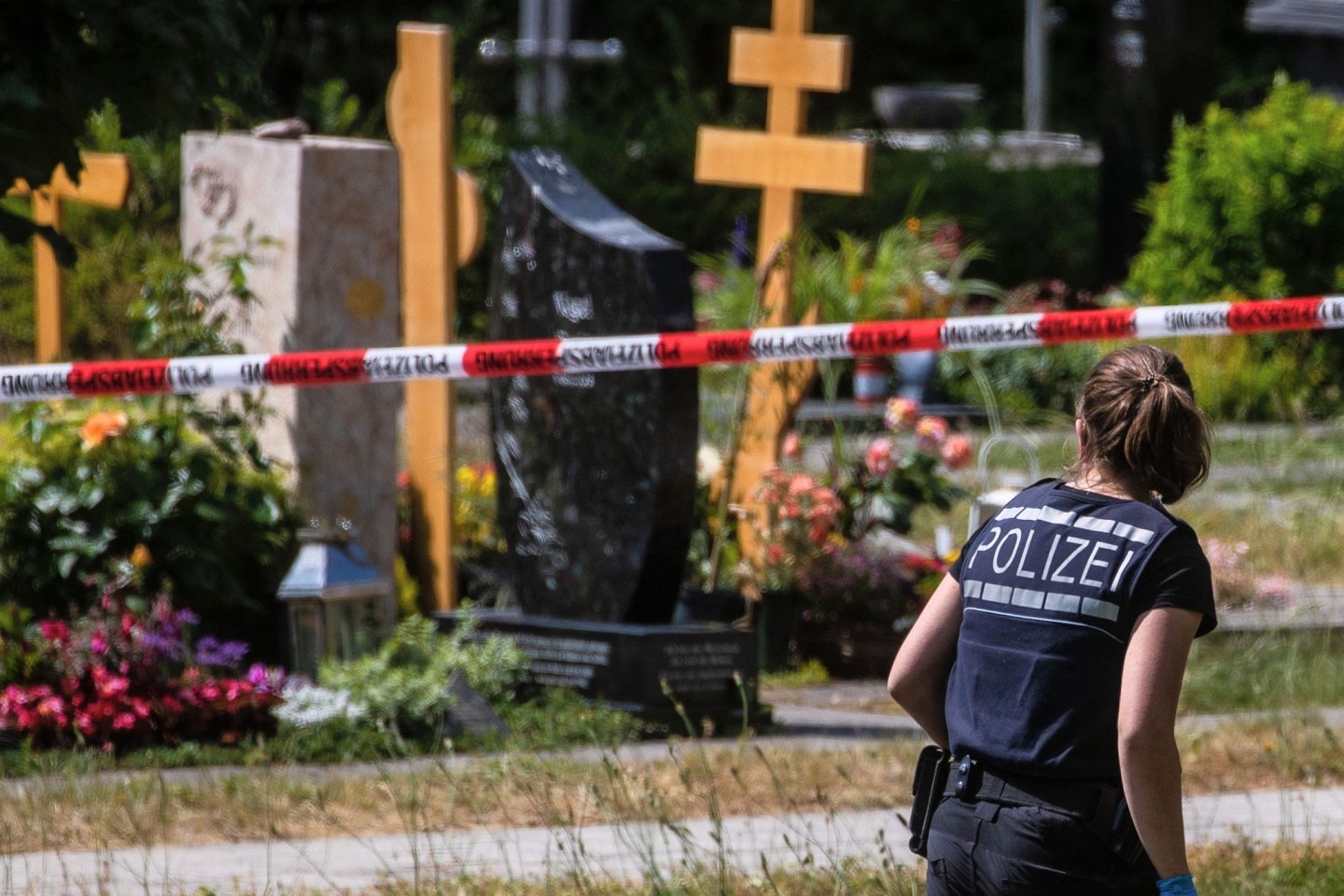 Eine Polizistin geht über den abgesperrten Teil eines Friedhofs in Altbach, wo im Juni eine Handgranate auf eine Trauergemeinde geworfen wurde.