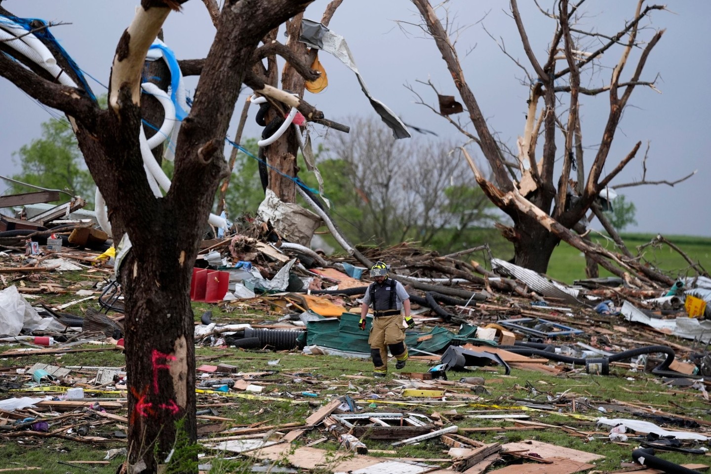 Ein Feuerwehrmann geht in Greenfield, Iowa, durch die Trümmer von Häusern, die vo einem Tornado zerstört wurden.